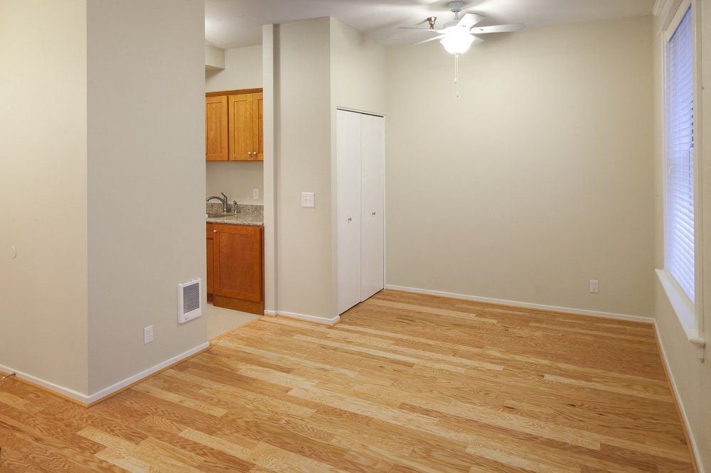 a living room with a hard wood floor and a kitchen