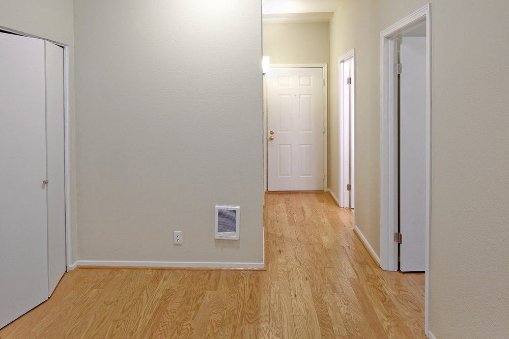 hallway with wooden floor and a white door