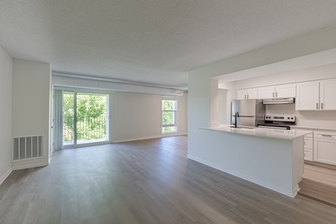 A spacious kitchen with white cabinets and a stainless steel refrigerator.