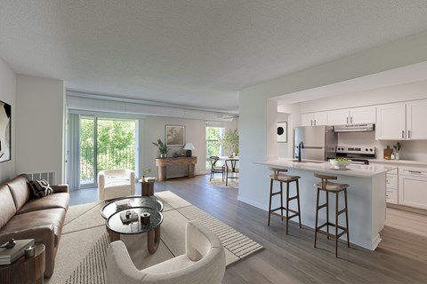 A modern living room with a kitchen in the background.