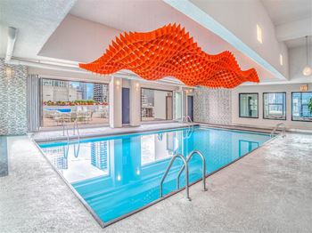 a swimming pool at a hotel with a large orange sculpture