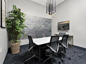 a conference room with a white table and chairs