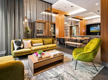 a living room with a yellow couch and a green chair