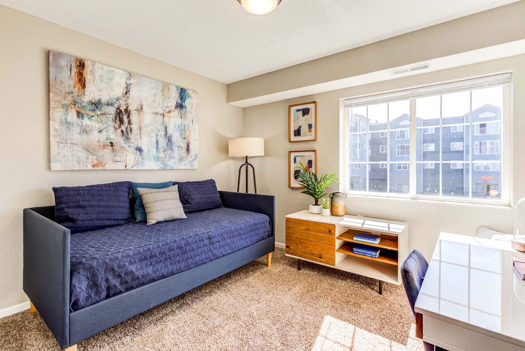 a living room with a couch and a desk