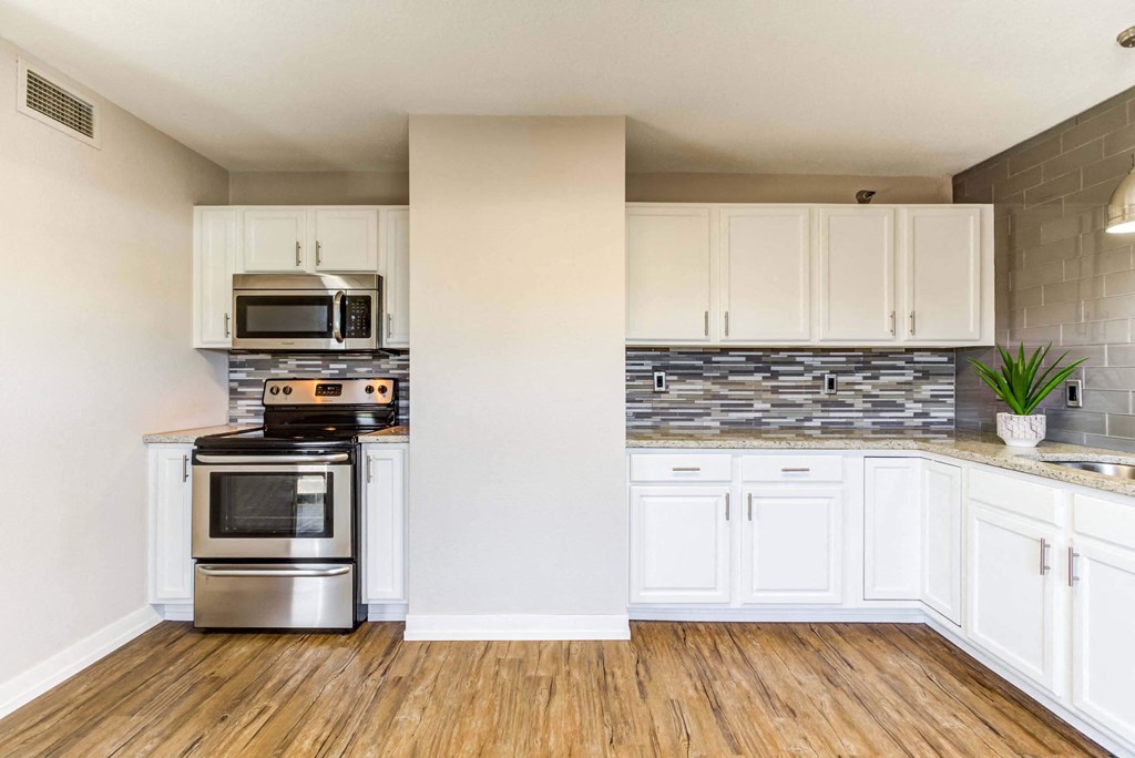 a kitchen with white cabinets and stainless steel appliances