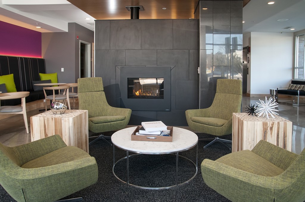 A sitting room with a fireplace and green chairs.