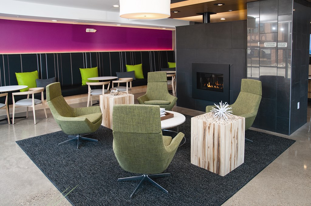 A sitting room with a fireplace and green chairs.