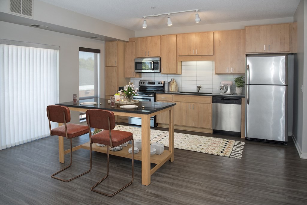 A kitchen with a table and chairs.