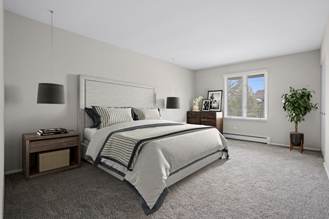 A bedroom with a large bed and a potted plant.