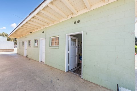 the side of a green building with an open door