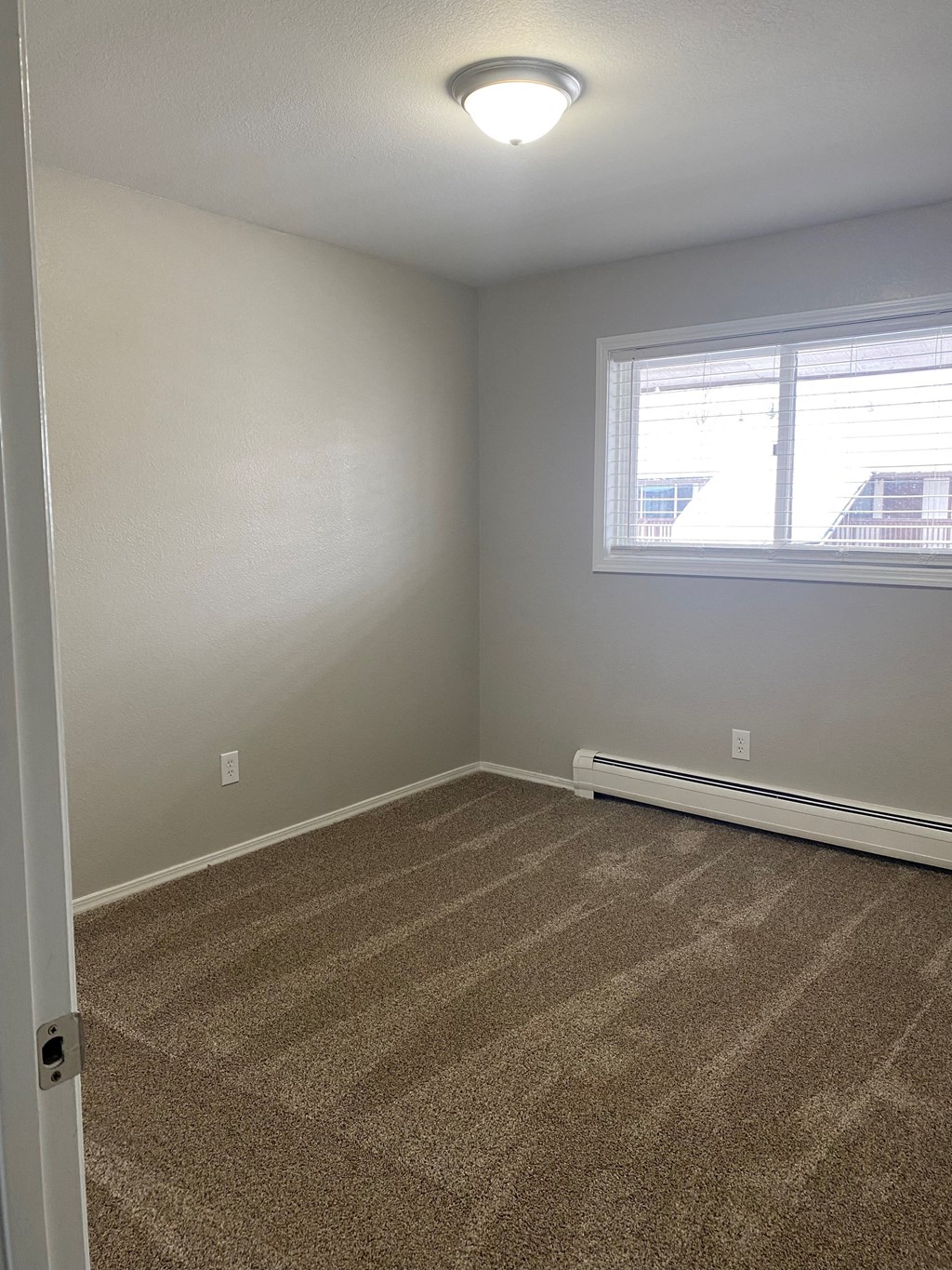 an empty room with carpet and a window