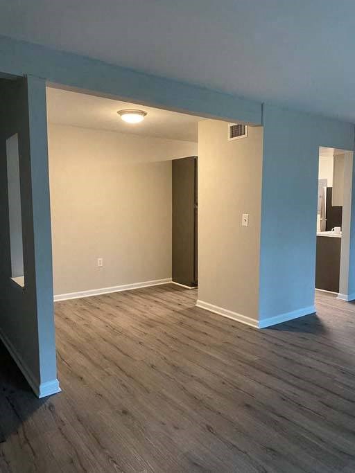 an empty room with a wooden floor and blue pillars at ReNew Odenton, Maryland