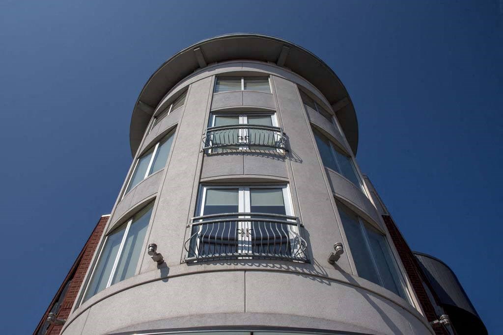 a tall building with two balconies and a blue sky at Flats at Southside, Pittsburgh, 15203