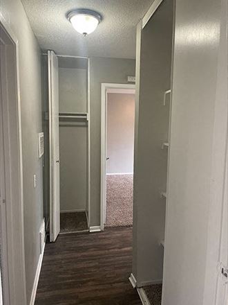 a hallway with a wooden floor and gray walls a hallway with a wooden floor and gray walls at Dwell Apartment Homes, California, 92507