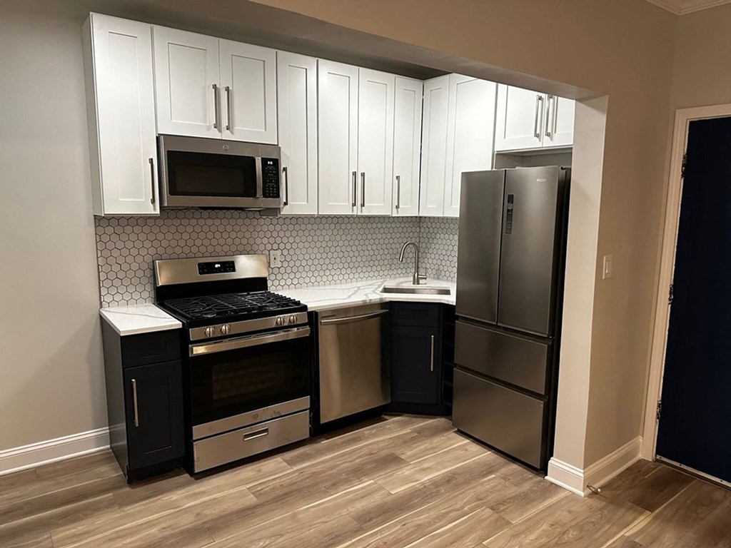 A kitchen with appliances and white cabinets at Evelyn Apartments, Oak Park, IL