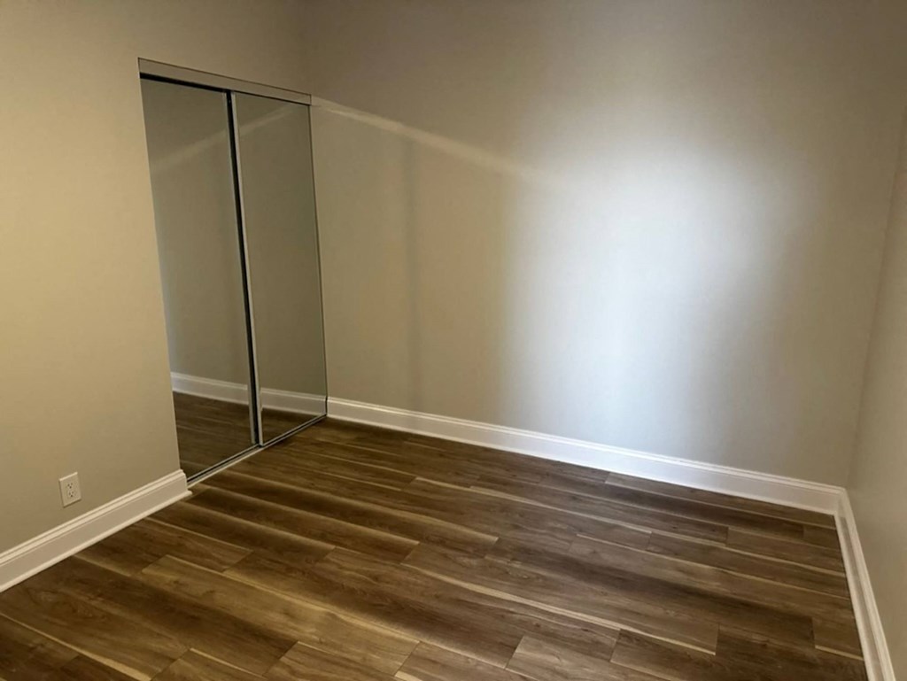 A room with a wooden floor and a mirrored closet at Evelyn Apartments, Oak Park