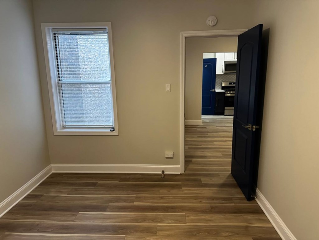 Bedroom with a wooden floor and a black door at Evelyn Apartments, Oak Park, 60304