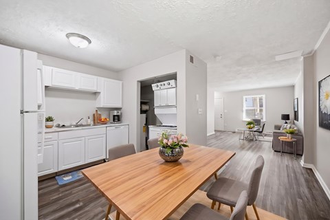 A modern kitchen with a wooden table and chairs.
