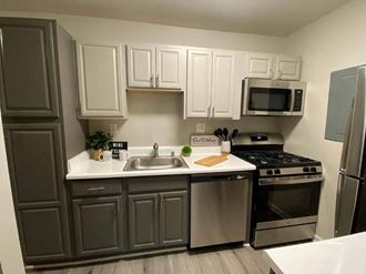 a kitchen with a sink a stove and a microwave at ReNew Odenton, Odenton, 21113