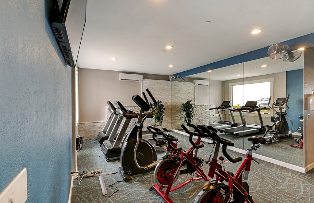 Fitness center with treadmills, ellipticals and bikes  at OceanAire Apartment Homes, Pacifica, CA