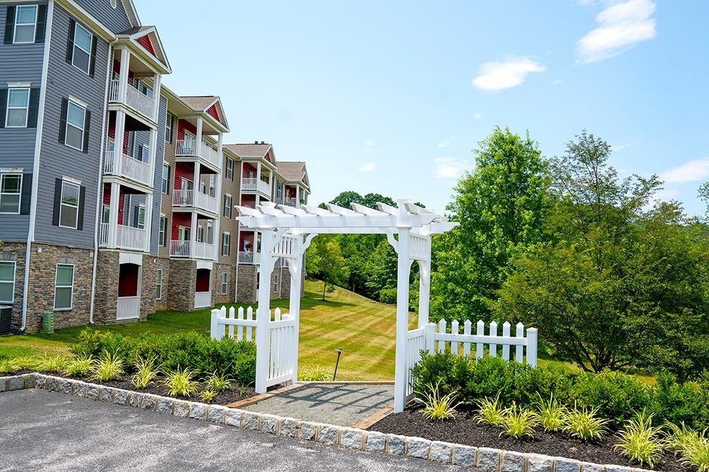a white arbor in front of an apartment building  at ReNew Glenmoore, Glenmoore, PA