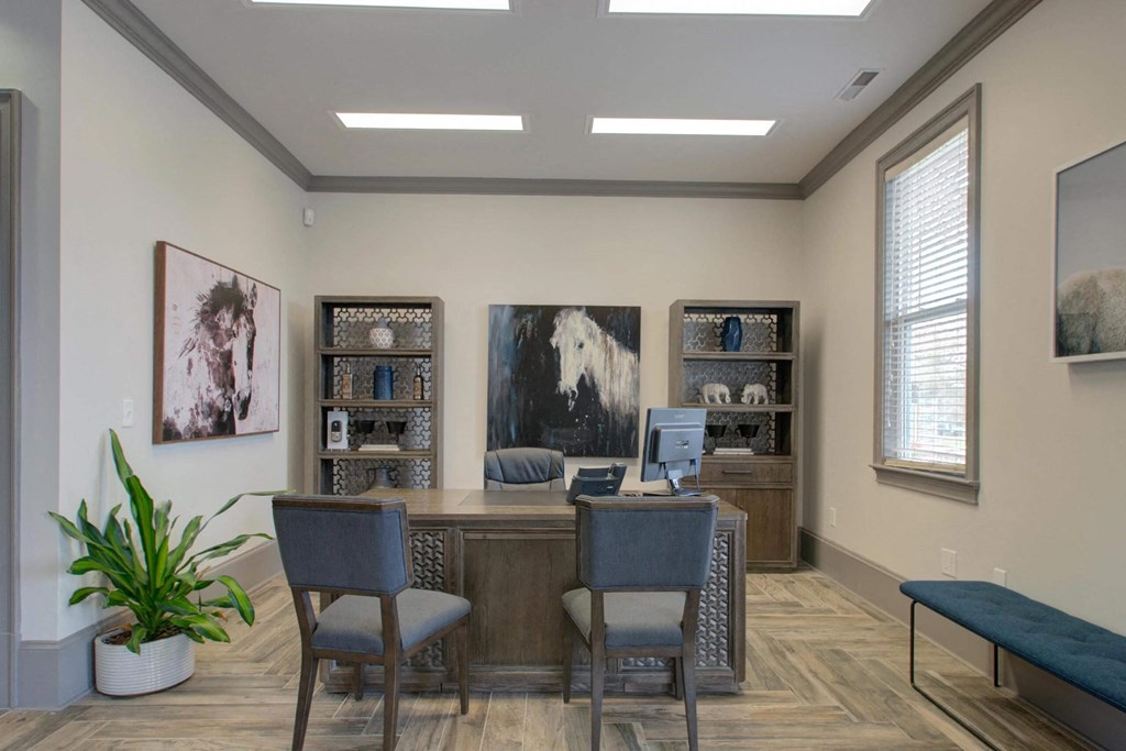 a desk with a computer and chairs in a room with a couch and bookshelves  at ReNew Glenmoore, Glenmoore, 19343