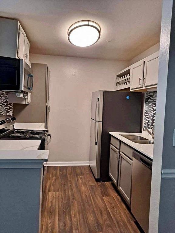 a kitchen with a stove a refrigerator and a sink  at ReNew Sugar Hill, Georgia
