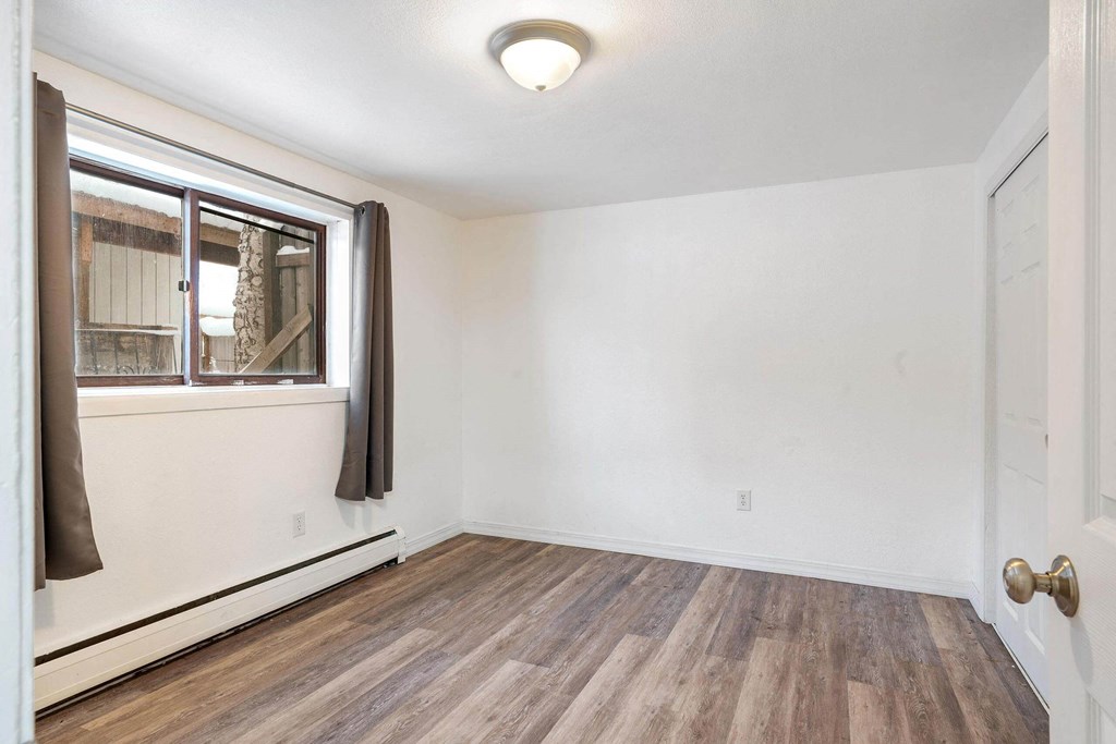 a bedroom with hardwood floors and white walls  at ReNew End Street, Alaska
