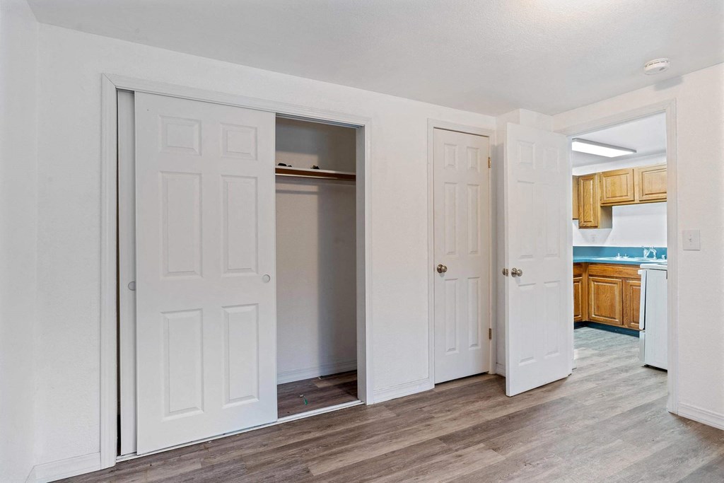 a bedroom with two doors and a kitchen in the background  at ReNew End Street, Alaska, 99577