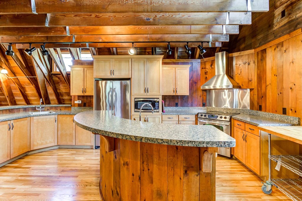 a kitchen with wooden cabinets and an island with granite countertops  at ReNew at Neill Lake, Minnesota, 55344