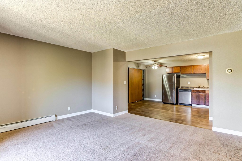 an empty living room with a kitchen in the background  at ReNew at Neill Lake, Eden Prairie, Minnesota