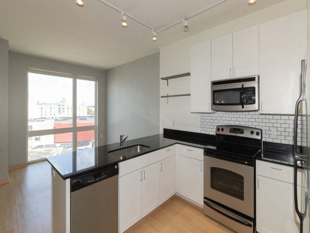 a kitchen with black counter tops and white cabinets