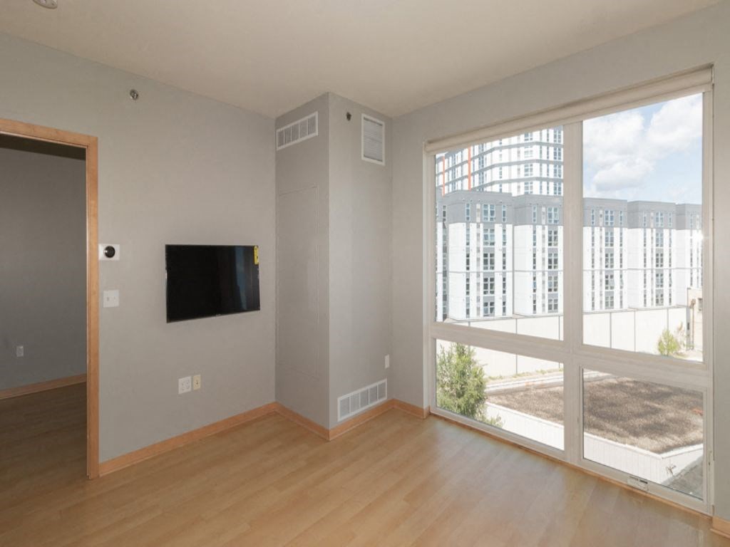 a living room with a large window and wooden floors