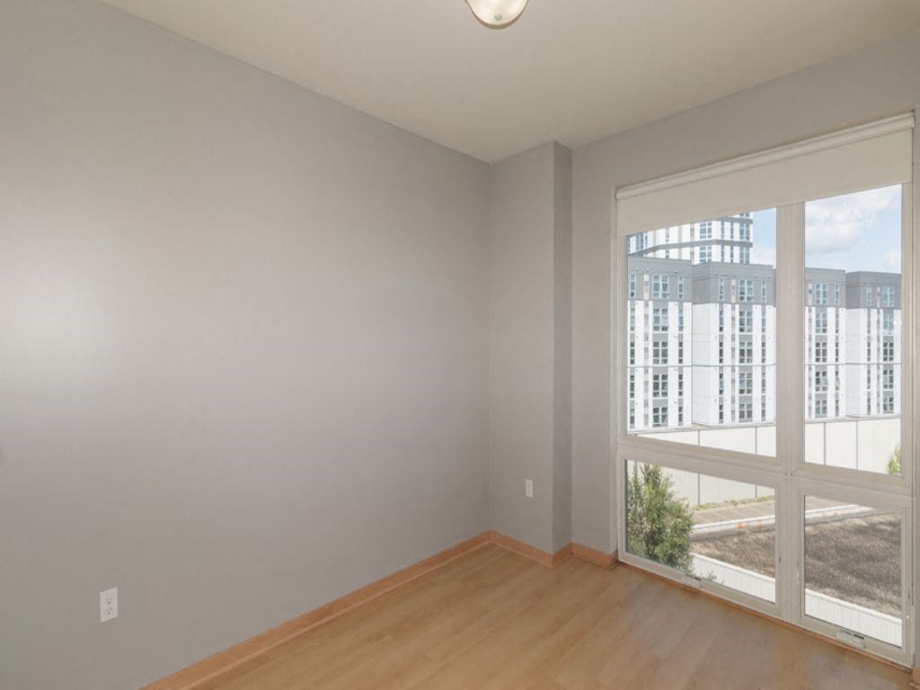 a living room with a large window and wooden floors