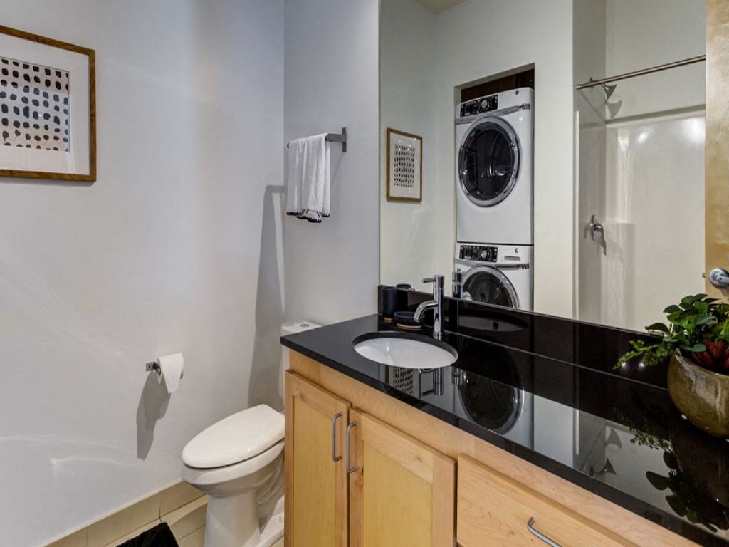 a bathroom with a toilet sink and a washing machine in it