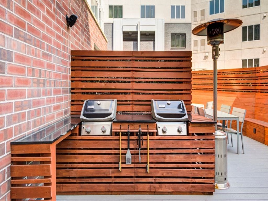 a large wooden deck with two barbecue pits on it