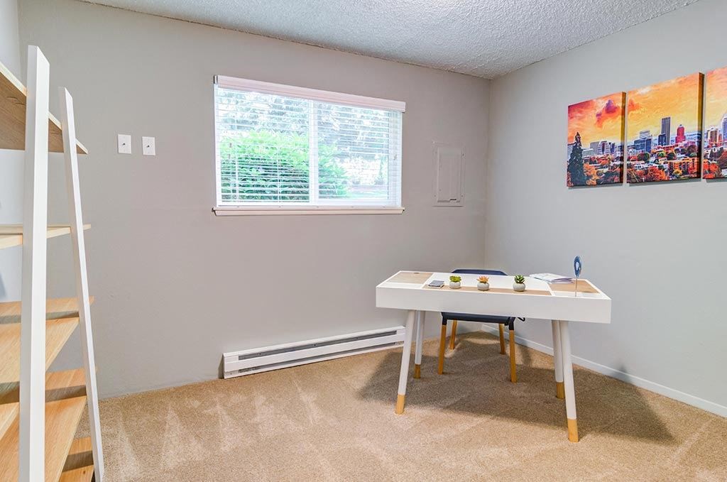 a bedroom with a bed and a desk in front of a window at The Bluffs at Mountain Park, Oregon