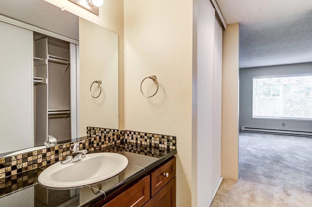 a bathroom with a sink and a mirror at The Bluffs at Mountain Park, Lake Oswego