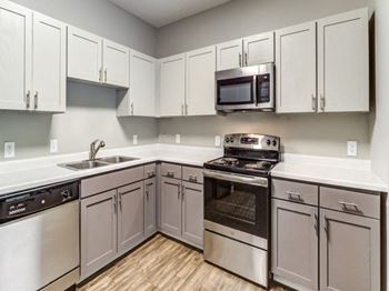 A kitchen with a stove top oven and a microwave above the sink.