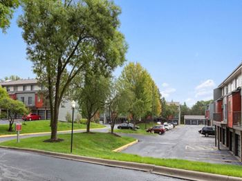 A parking lot with cars and trees in front of a building.