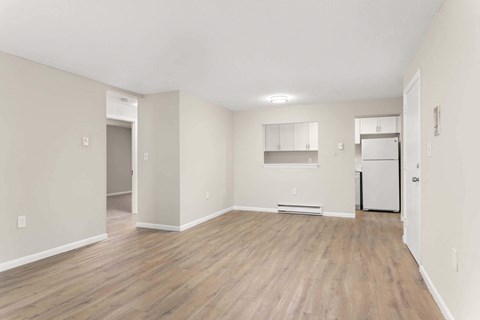 an empty living room with white walls and wood floors