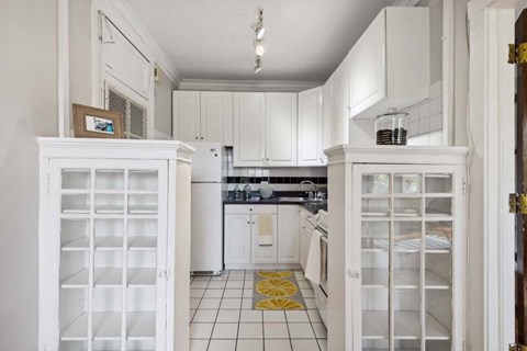 a white kitchen with white cabinets and a door