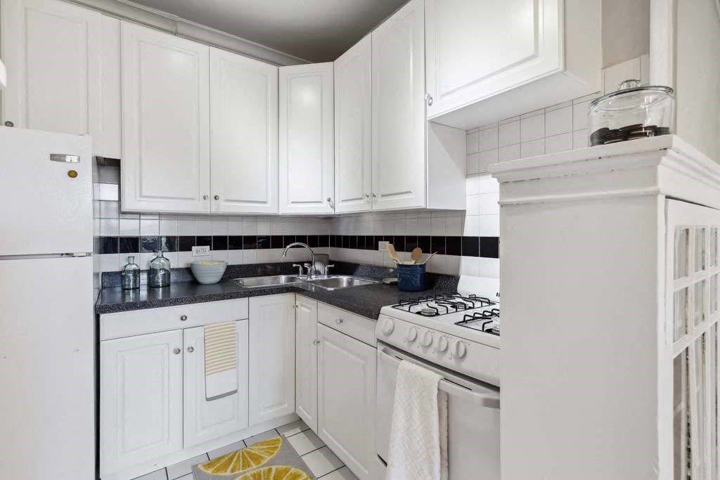 a white kitchen with white appliances and white cabinets at The Bryant at Oak Park I & II, Illinois