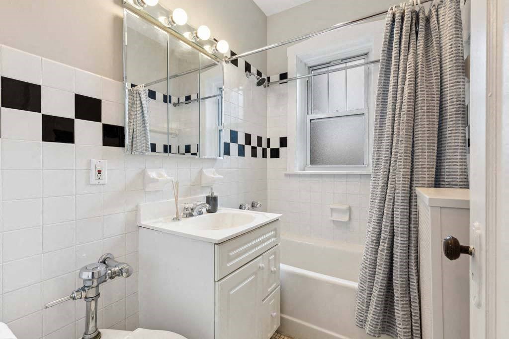a bathroom with a sink and a mirror and a shower at The Bryant at Oak Park I & II, Illinois