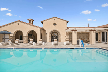 a swimming pool in front of a house with a pool