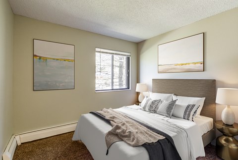 A bedroom with a large bed and two framed pictures on the wall.