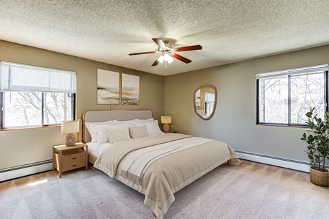 A bedroom with a large bed and a ceiling fan.