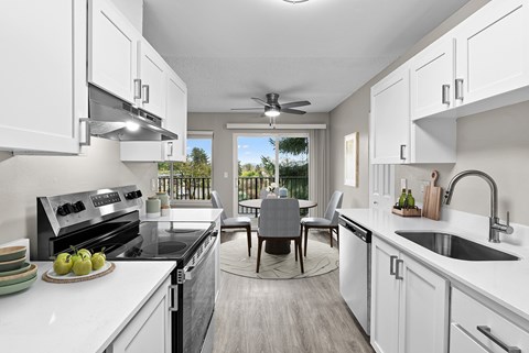 A modern kitchen with a dining table and chairs in the middle.