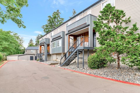A modern two-story apartment with a grey exterior and a red border around the driveway at River Lofts Apartments, Tualatin, OR, 97062