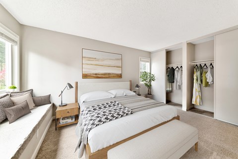 A bedroom with a large bed, a bench, and a wardrobe.